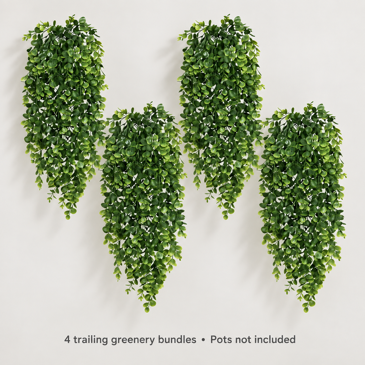 Four trailing artificial greenery bundles with small oval leaves — neutral studio