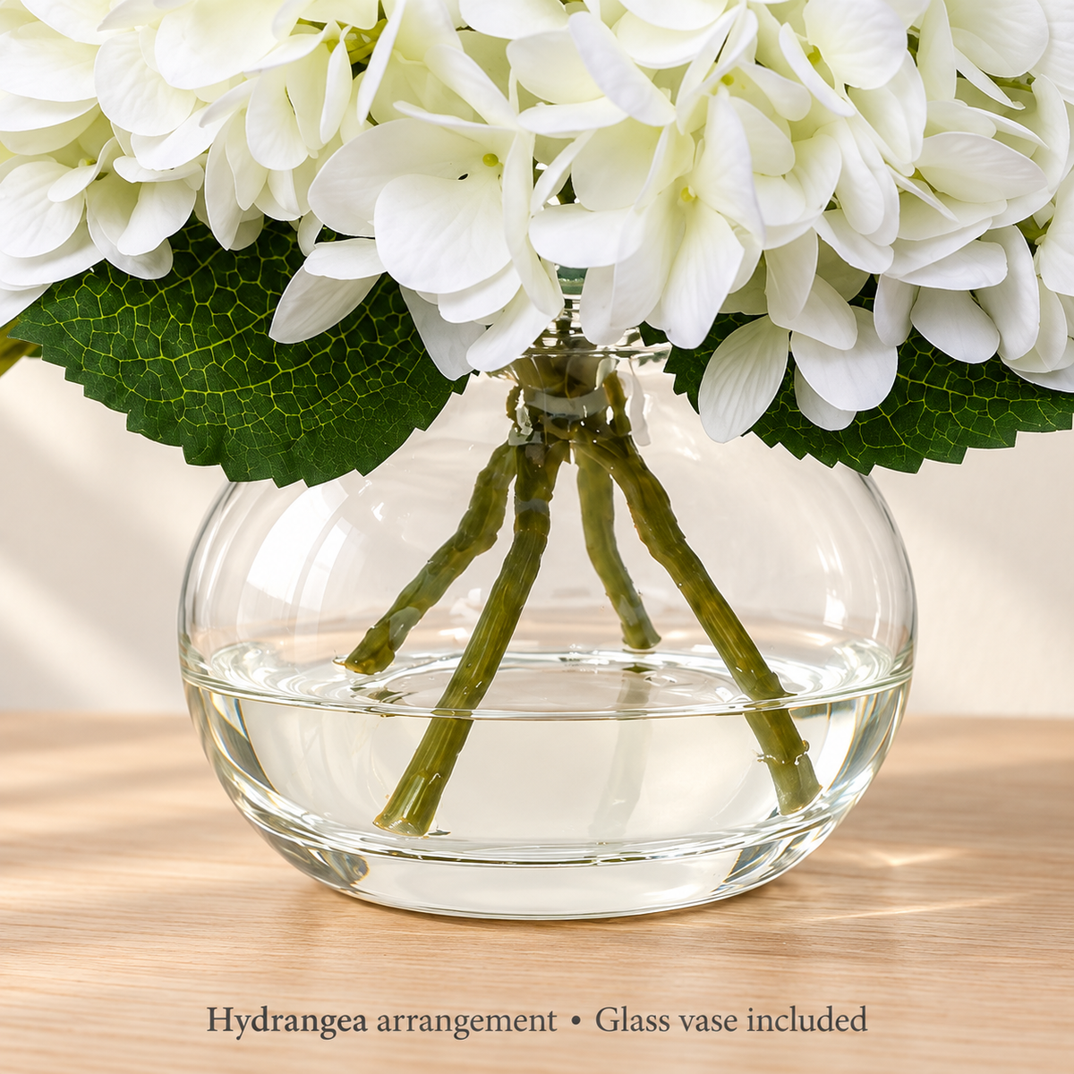 White hydrangea arrangement in glass vase with faux water — lower detail