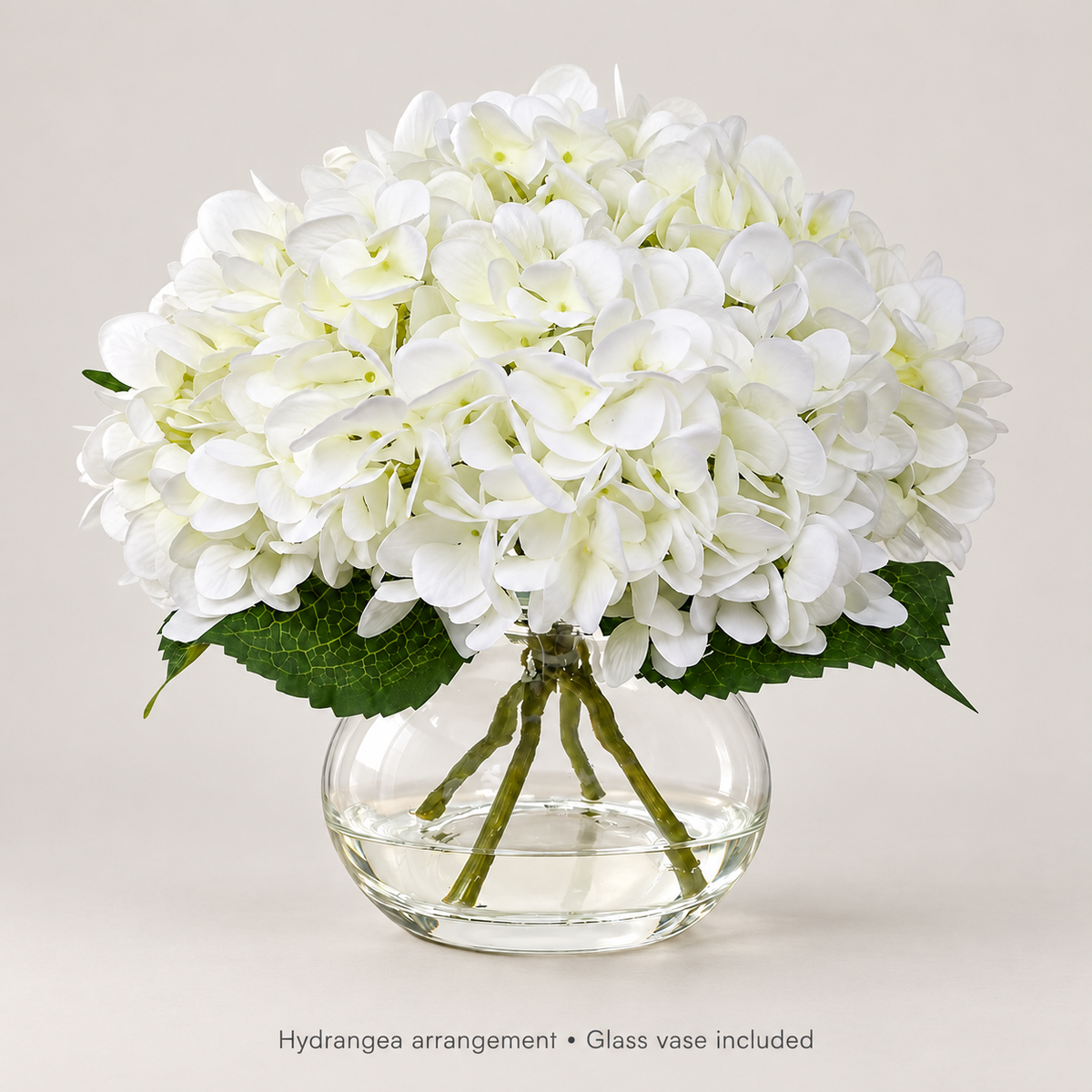 White hydrangea arrangement in glass vase with faux water — neutral studio