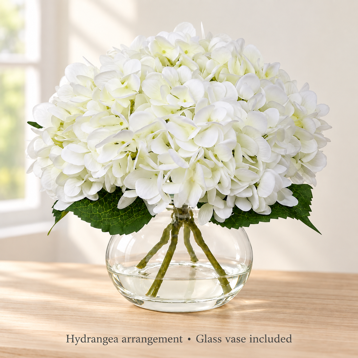 White hydrangea arrangement in glass vase with faux water — window light