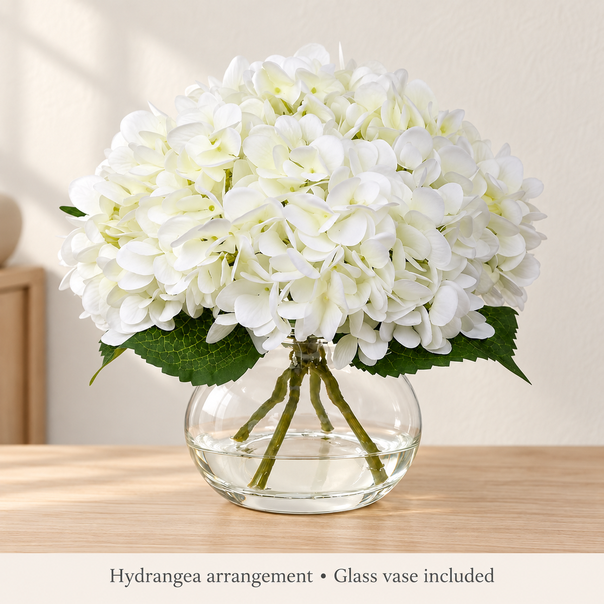 White hydrangea arrangement in glass vase with faux water — minimal room